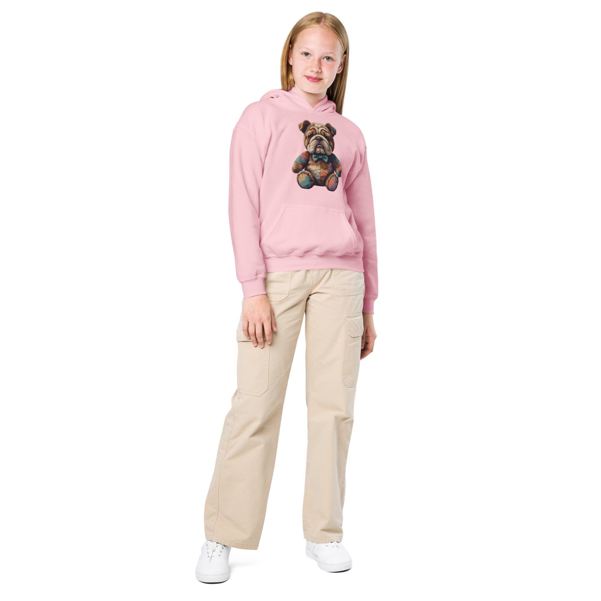 Young girl wearing a pink hoodie with a graphic design and beige pants on a white background